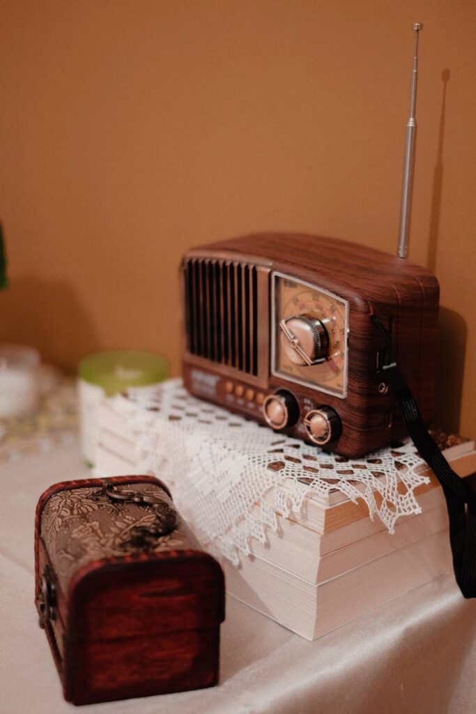 Retro radio and wooden box on a tabletop with lace cloth, evoking nostalgia.