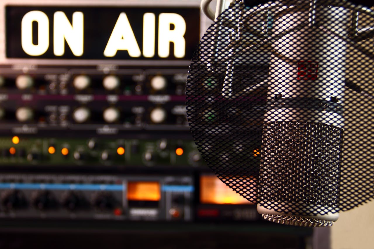 Quand la Terre écoute : La Voix qui restaure les Destins Close-up of a radio microphone and control panel in an illuminated studio.